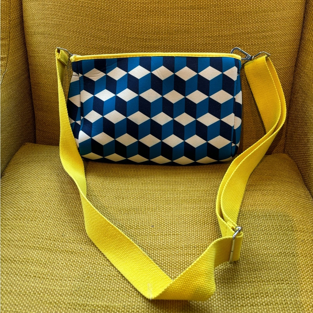 Ah dorned crossbody bag with blue geometric pattern.
